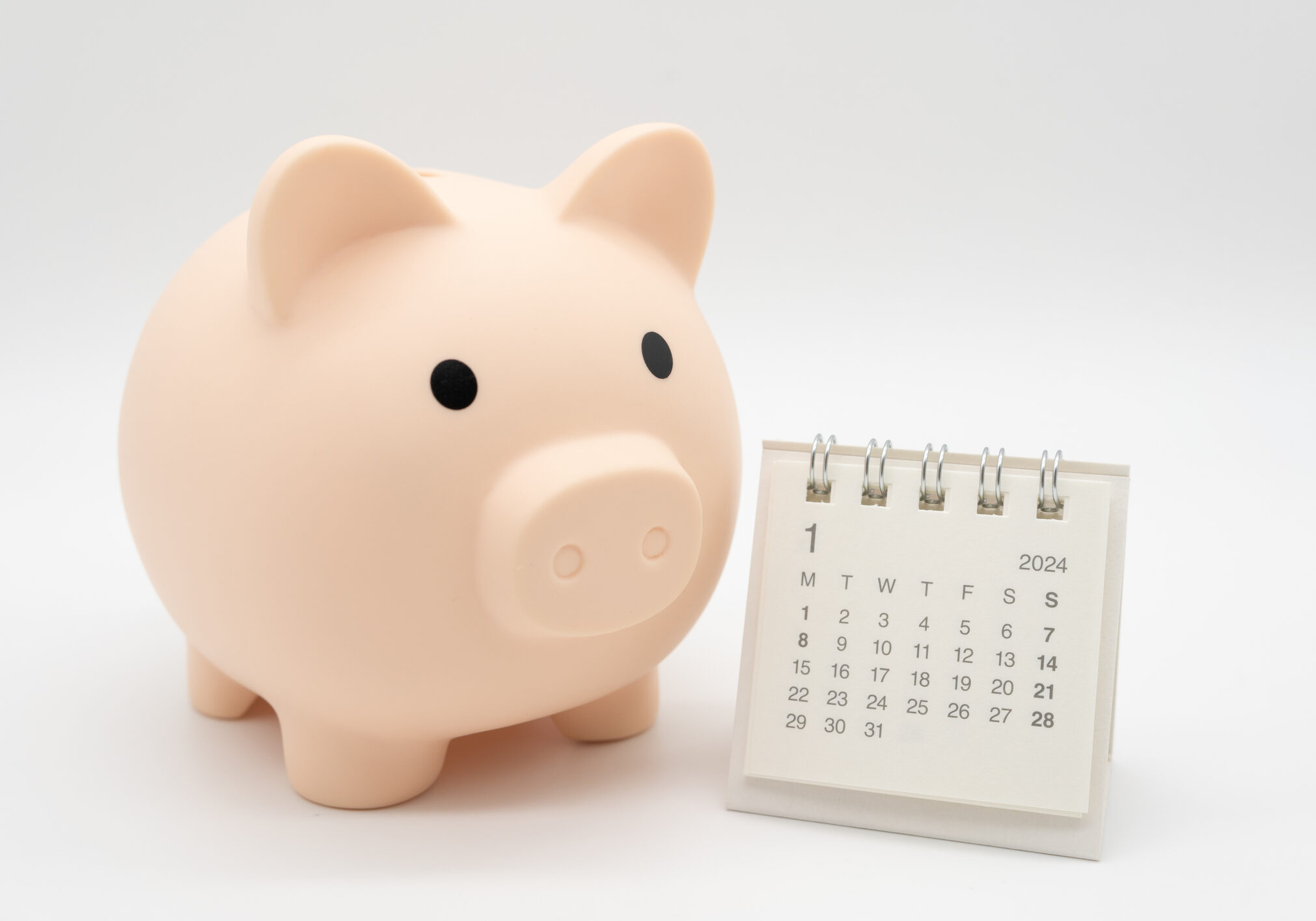 Piggy Bank and Desk calendar isolated on white background. For retirement, Pension Plan concept. Time for a new start.